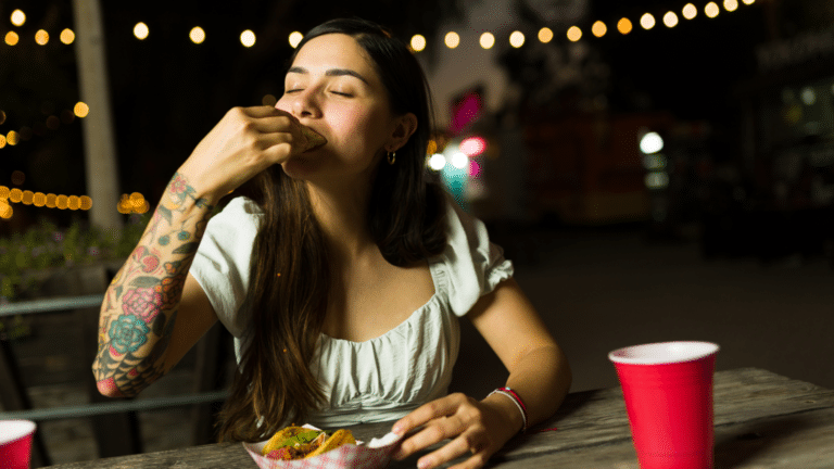 night scene of girl eating a taco at a picnic table
